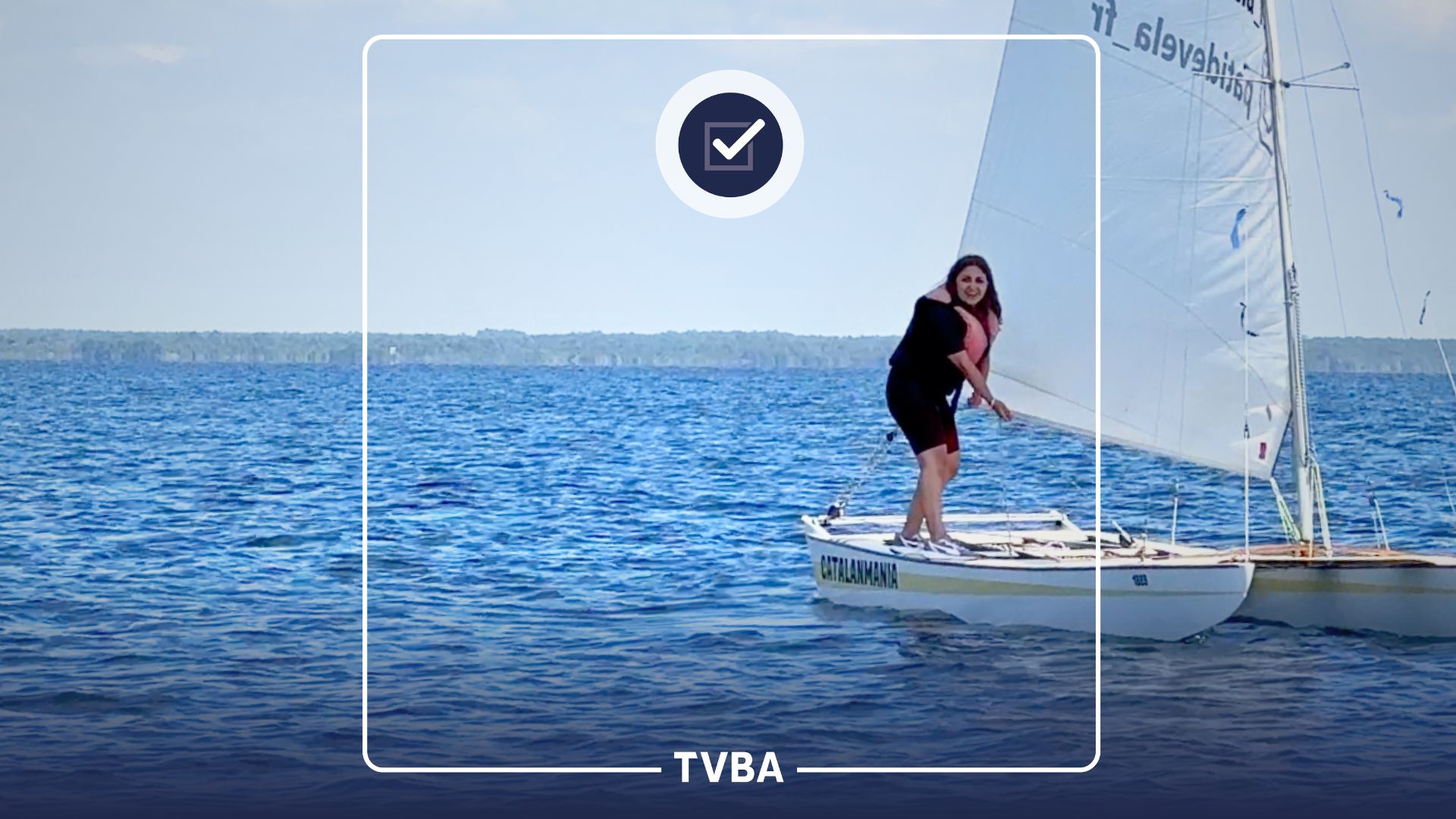 Femme debout sur un bateau pratiquant du "Patin à voile"