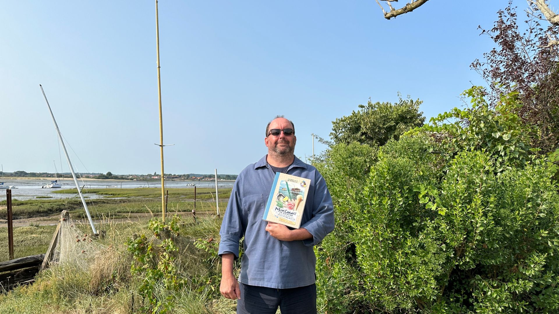 Laurent Bardou tenant son livre dans les bras devant l'Aiguillon