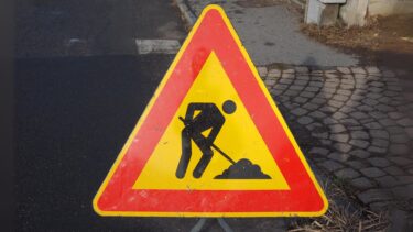 panneau de chantier triangulaire indiquant des travaux posé sur une toute