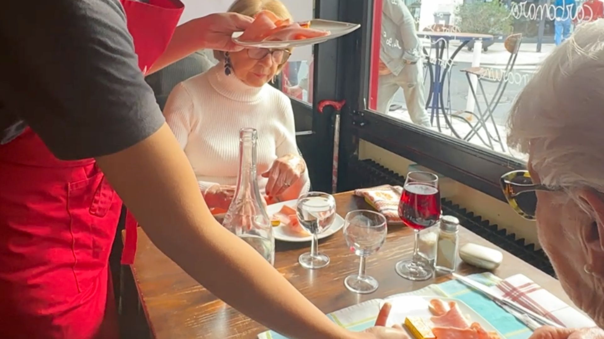 Deux dames à la table d'un restaurant devant une fenêtre