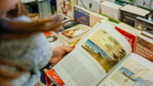 Jeune femme feuilletant un livre dans une librairie