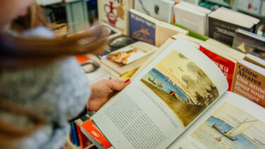 Jeune femme feuilletant un livre dans une librairie