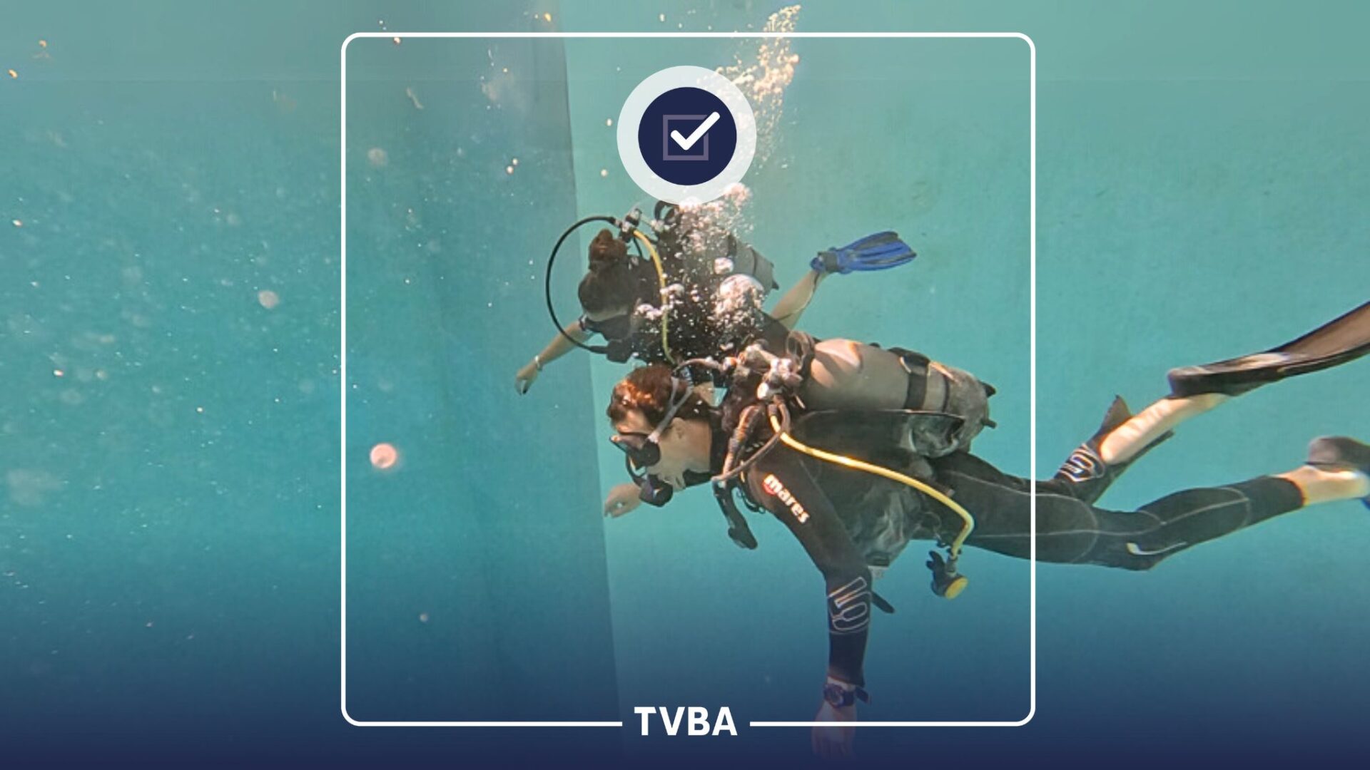 Deux personnes font de la plongée sous marine dans une piscine