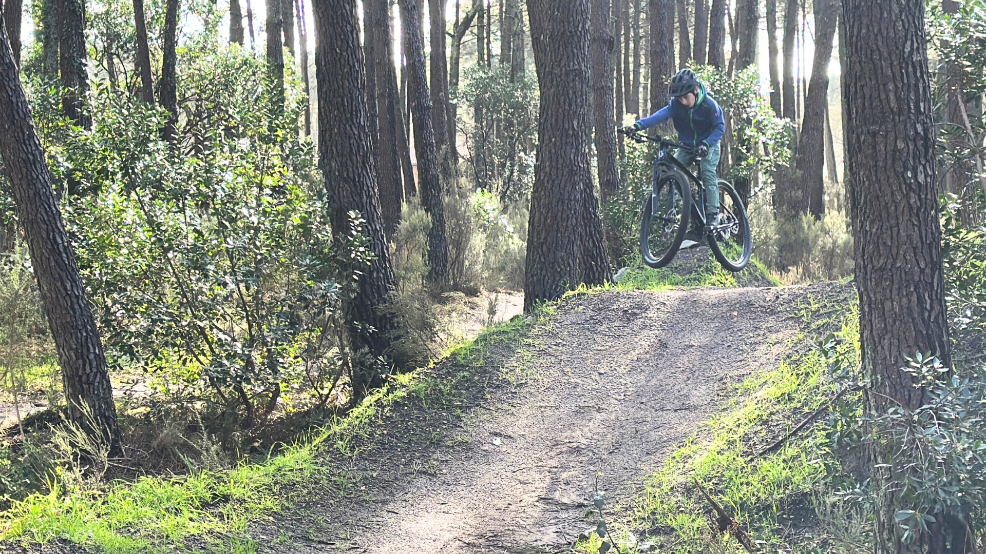 jeune garçon sur un VTT qui effectue un saut sur la piste de VTT de La Teste dans la forêt