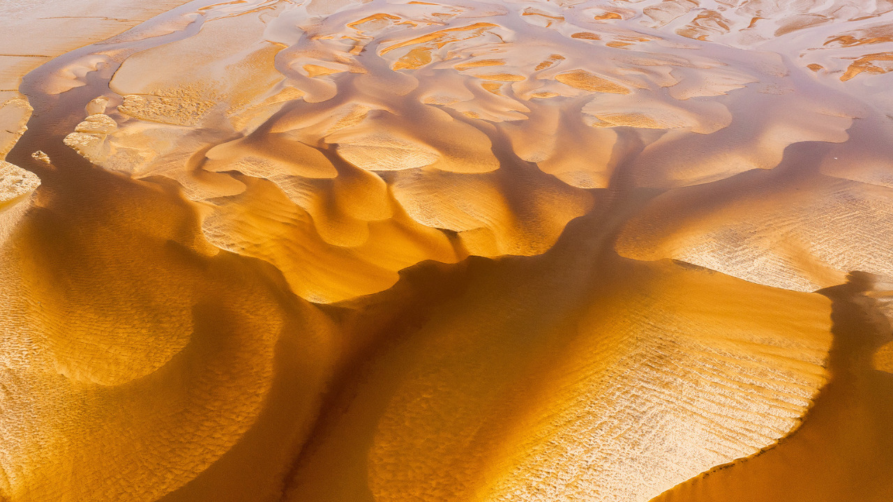 Vue drone des bancs de sable du Bassin, à marée basse, donnant une impression de peinture à l'eau couleur café