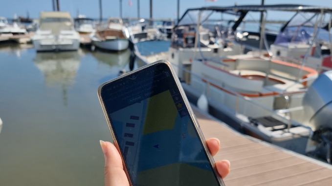 un telephone tenu en main devant un port