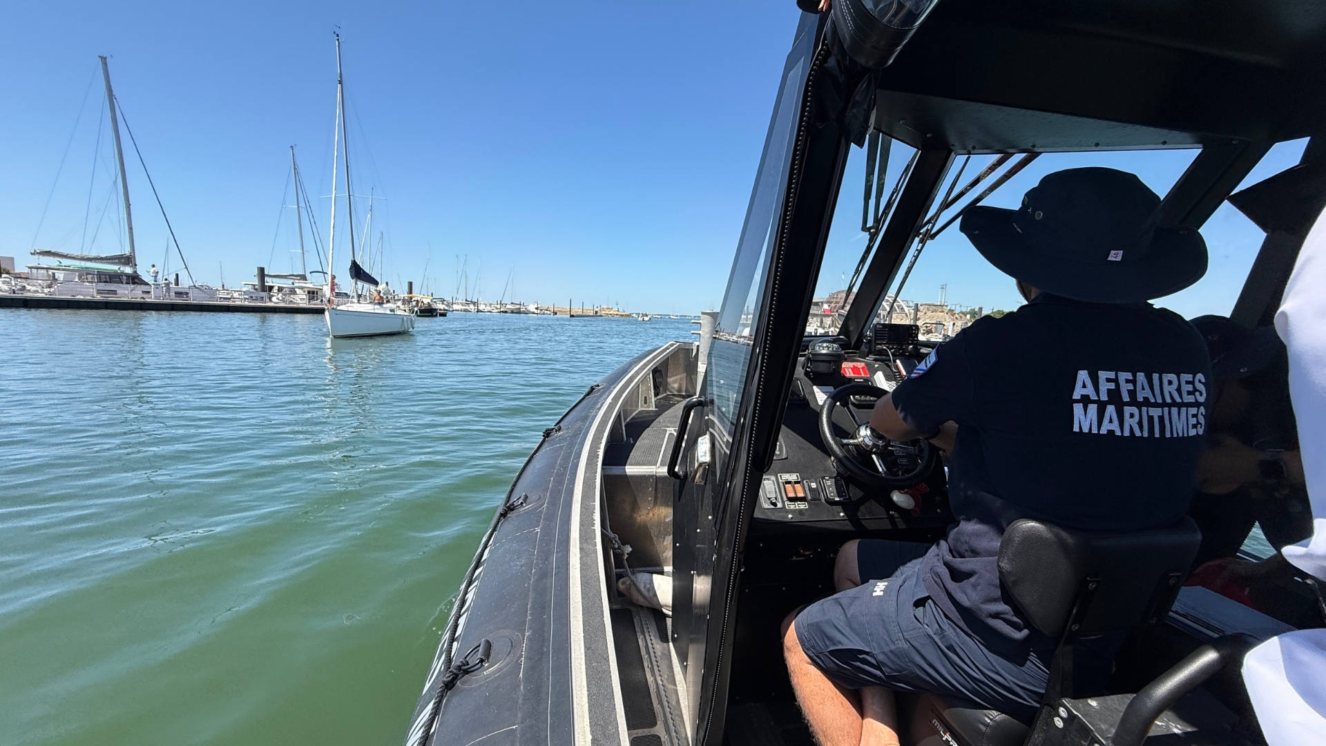 agent des affaires maritimes de dos qui conduit un semi-rigide dans le port d'arcachon à l'occasion de la journée sécurité en mer