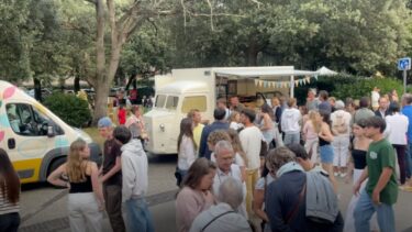 des personnes en extérieur avec des foodtrucks en arrière plan pour la deuxième édition de Happyla