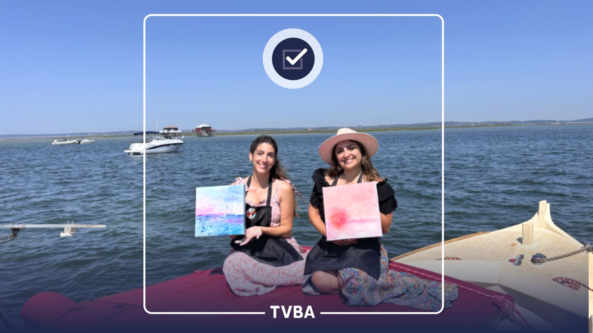 deux jeunes femmes sur un bateau avec un tableau dans le smains chacune