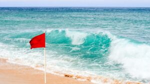 image d'illustration vague et drapeau rouge sur la plage