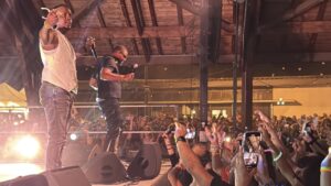 chanteur en vston blanc sous une halle pleine de monde