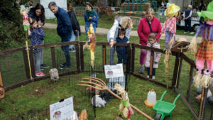enfants et parents devant un enclos à lapins