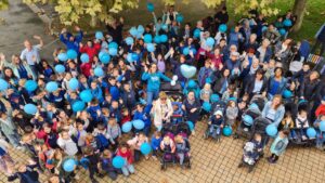 photo vue du ciel d'un groupe de personne avec des teeshirt et ballons bleus