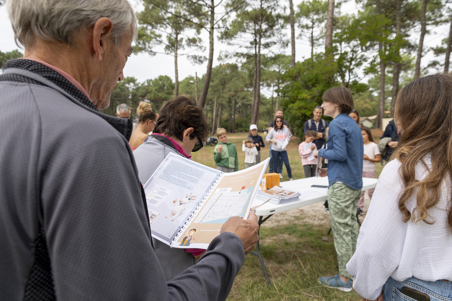 groupe de personnes dans une forêt, debout autour d'une guide