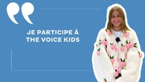 Wylie, jeune fille souriante qui porte une veste blanche avec des fleurs roses et vertes dessus, sur un fond bleu avec la mention "je participe à the voice kids".