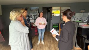 4 femmes en train de discuter dans une pièce aux murs gris