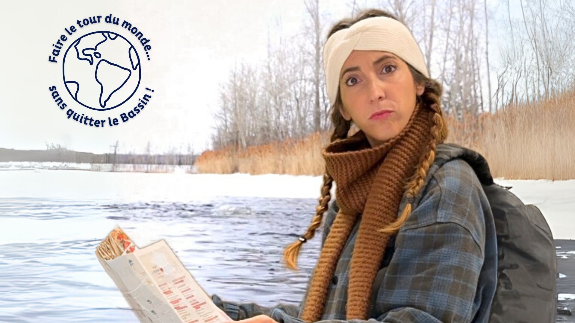 Une jeune femme en tenue hivernale tient une carte. Paysage enneigé à l'arrière