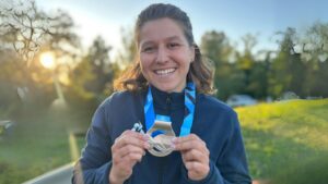 elsa gaubert, jeune femme championne de canoe qui tient sa médaille dans les mains
