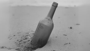 bouteille de vin plantée dans le sable, image en noir et blanc
