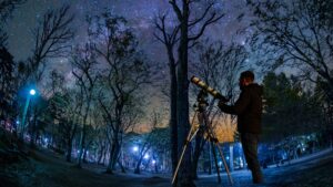 les étoile la nuit dans une foret. Un homme avec un telescope