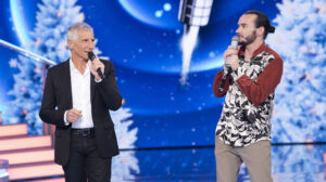 deux hommes tiennent un micro dans leur main sur un plateau de télévision