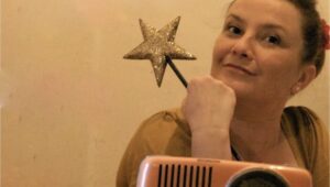 Une dame sur find jaune tient une baguette magique dans la main