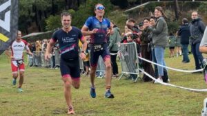 coureurs sur la ligne d'arrivée du 20e triathlon d'arcachon avec des supporters derrière des barrières