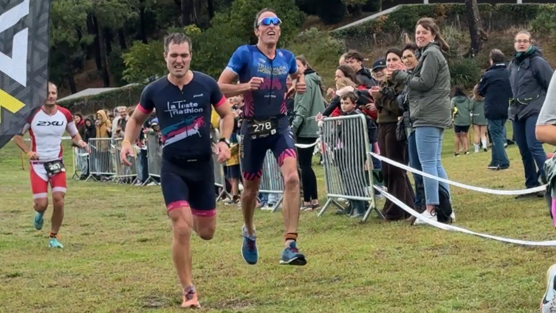 coureurs sur la ligne d'arrivée du 20e triathlon d'arcachon avec des supporters derrière des barrières