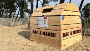 bac à marée : structure rectangulaire en bois posée sur le sable, une forêt en arrière plan