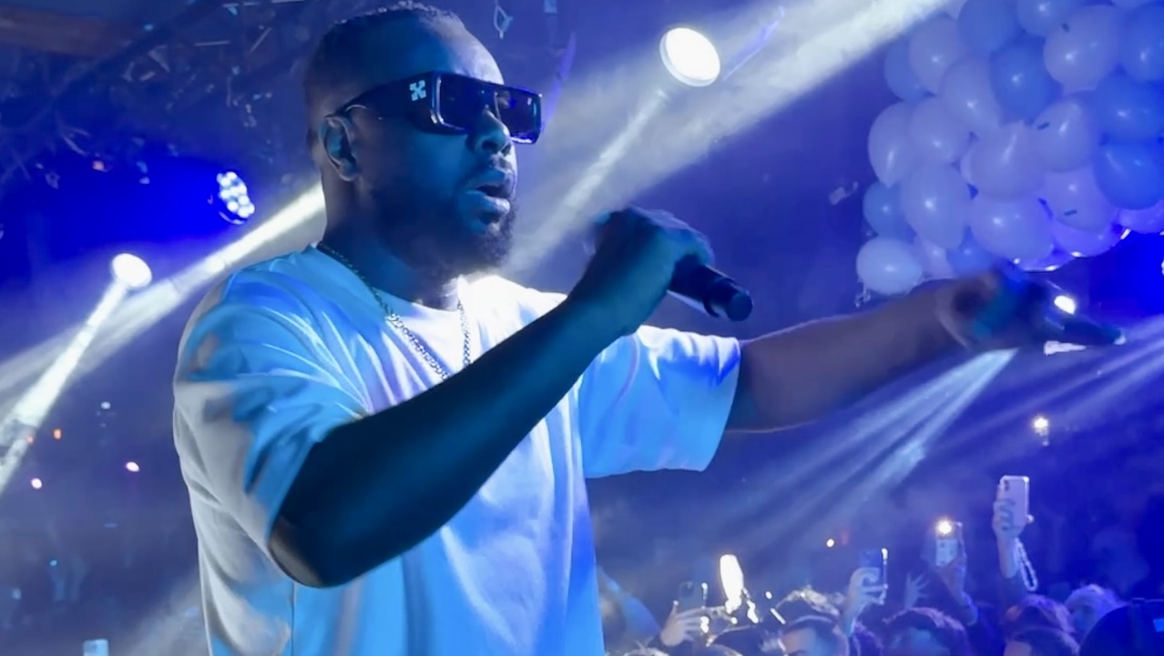 chanteur en tee-shirt blanc sur une scene illuminée en bleue