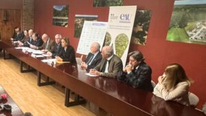 des gens alignés à une table marron dans une pièce au murs marrons