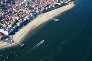 vue aerienne d'une ville en bord de mer, plage et jetées.