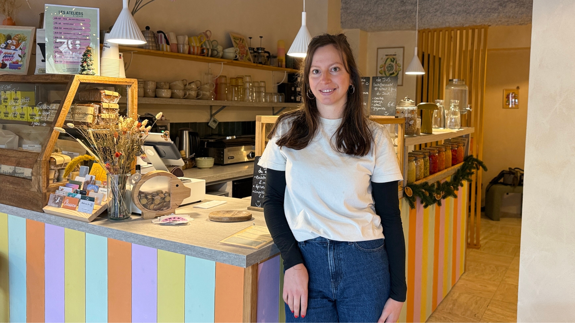 amélie, gérante de fermento à arcachon un café-brunch autour de la fermentation naturelle. Jeune femme brune souriante devant un comptoir coloré