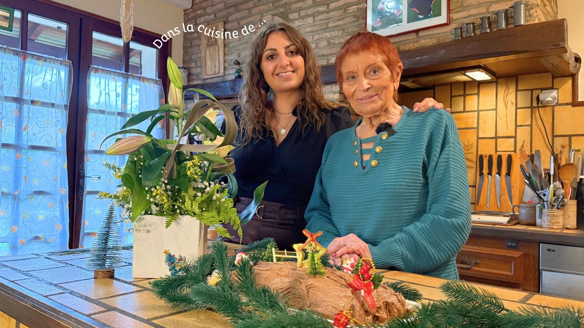 2 femmes dans une cuisine avec une buche de Noël et un bouquet de fleurs devant elles