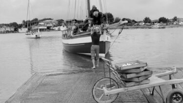 pêcheurs de sardine de retour de la pêche. Le bateau est au bord de la cale de mise à l'eau, une charrette au premier-plan avec des sardines dedans