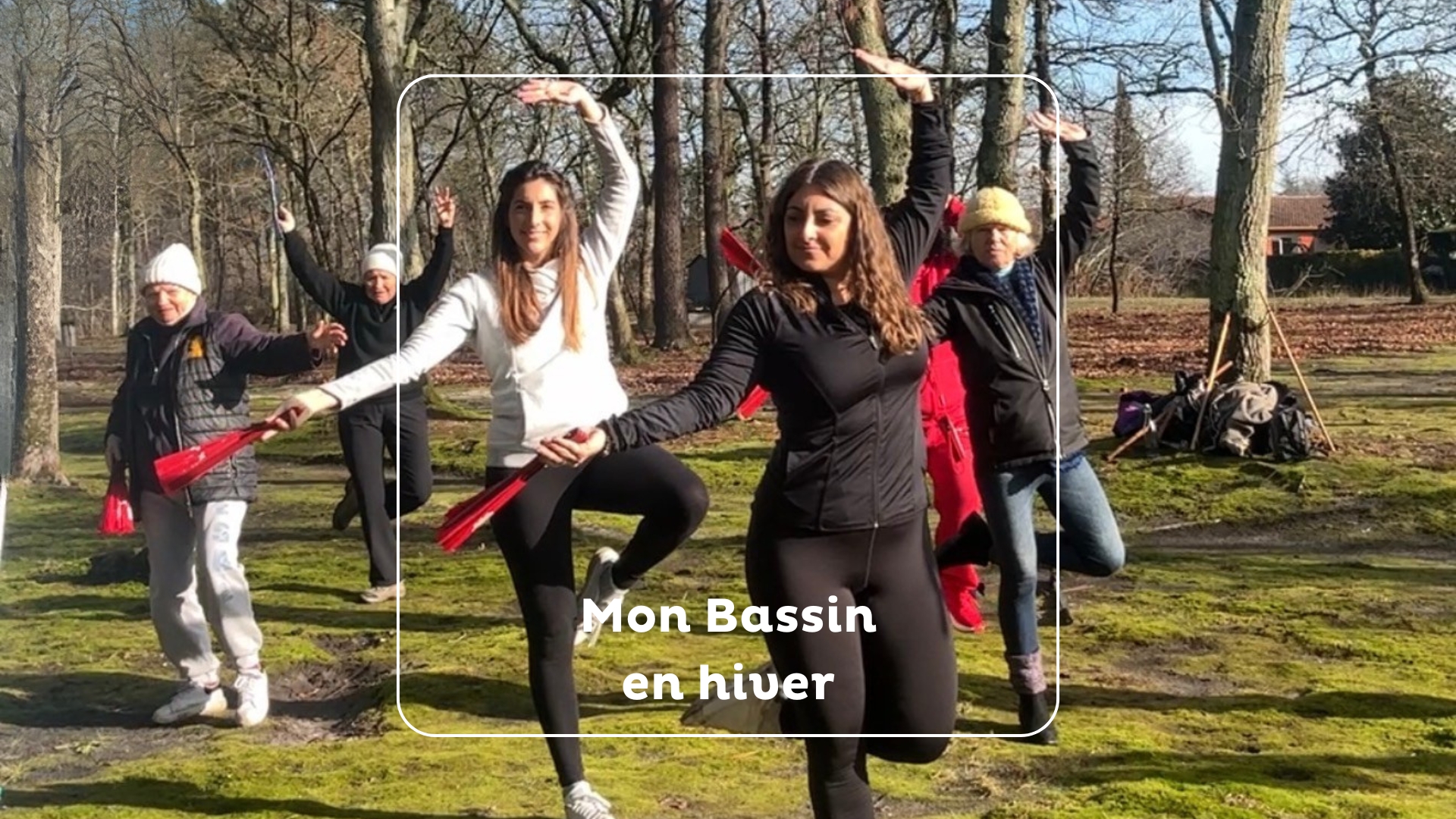 deux jeunes femmes au premier plan en train d'effectuer une posture de dao yin. Elles tiennent des éventail dans la main. Elles sont dans une chênaie avec d'autres participants en arrière plan