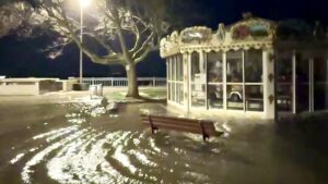 place submergée par l'eau, un carroussel entouré d'eau. il fait nuit