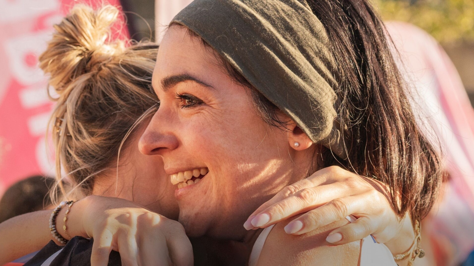 jeune femme souriante qui prend une autre femme dans ses bras