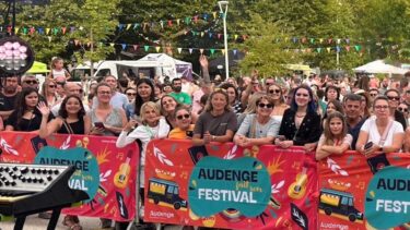 foule de personnes derrière des barrières colorées avec la mention "audenge fait son festival"