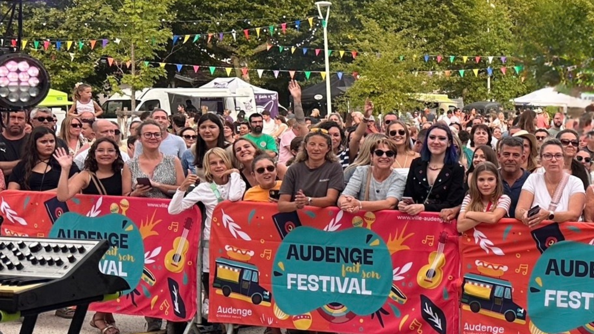 foule de personnes derrière des barrières colorées avec la mention "audenge fait son festival"