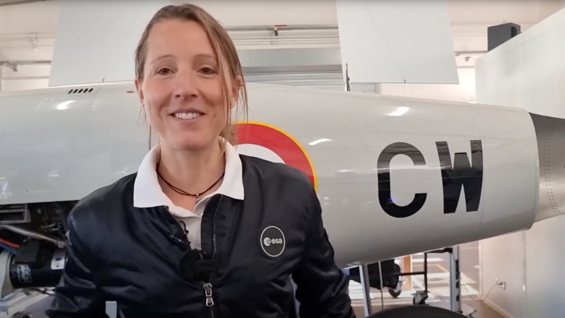 astronaute sophie adenot avec un avion de la ba120 derrière elle