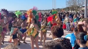 foule de personnes autour de danseuse en tenue de carnaval sous un beau ciel bleu