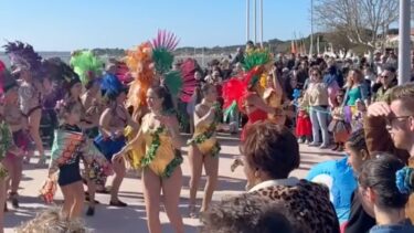 foule de personnes autour de danseuse en tenue de carnaval sous un beau ciel bleu