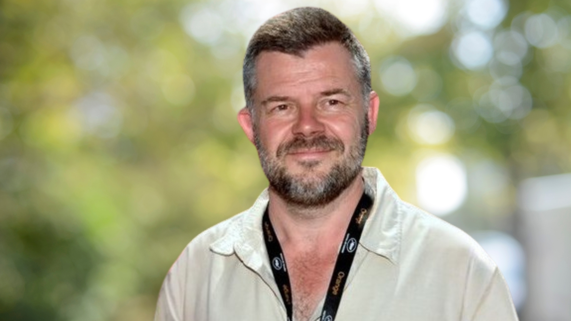 Eric Naulleau : un homme avec des cheveux brun une barbe grisonnante avec une chemise beige de face.