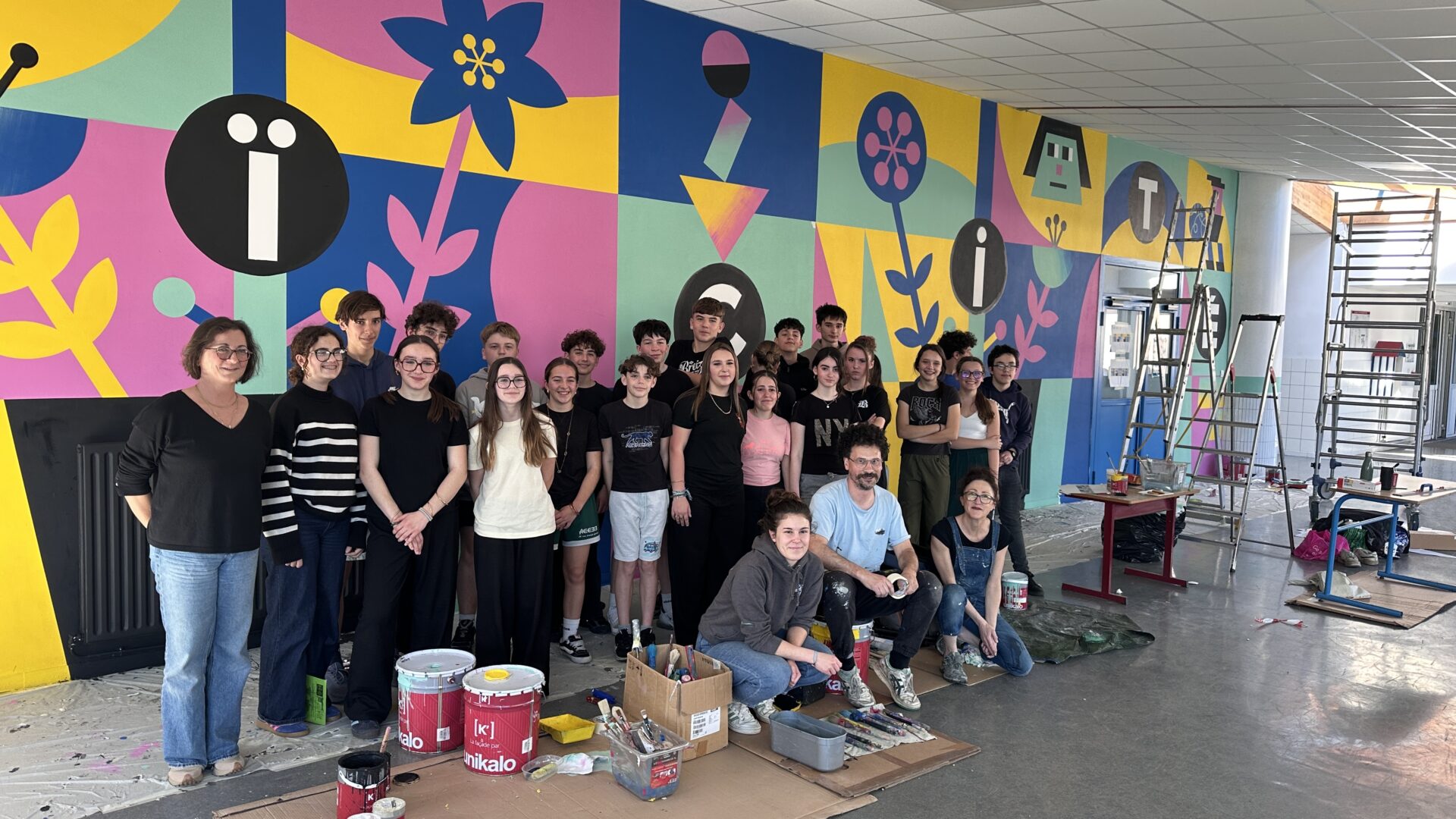 Une classe de 4e devant la fresque qu'ils ont réalisé à l'aide d'un artiste. Représentant la laïcité.