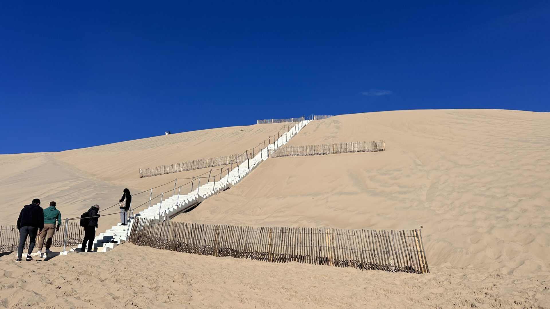 Escalier de la Dune du Pilat avec des personnes entrain de la monter.