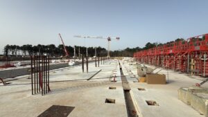 une immense dalle en béton sur un chantier. Au loin une grue