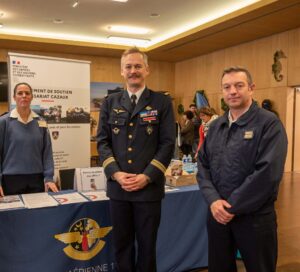 Photo montrant un colonel de la base aérienne de Cazaux, de l'adjoint au chef GSC, et une femme de l'amée derrière le stand de recrutement
