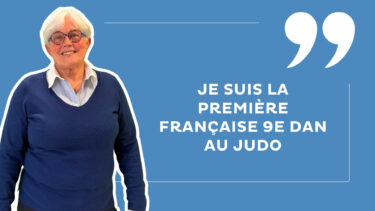 femme avec des cheveux blancs, des lunettes bleues, un pull bleu et une chemise blanche sur un fond bleu ciel avec la mention "Je suis la première Française 9e dan au judo"