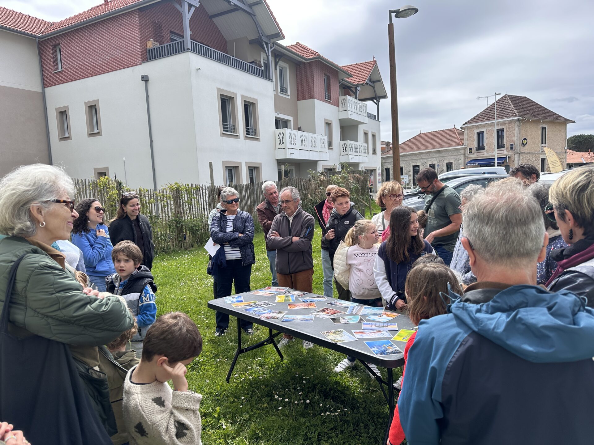Un groupe de personnes participe à une activité avec des images liées au cycle de l'eau, en extérieur.